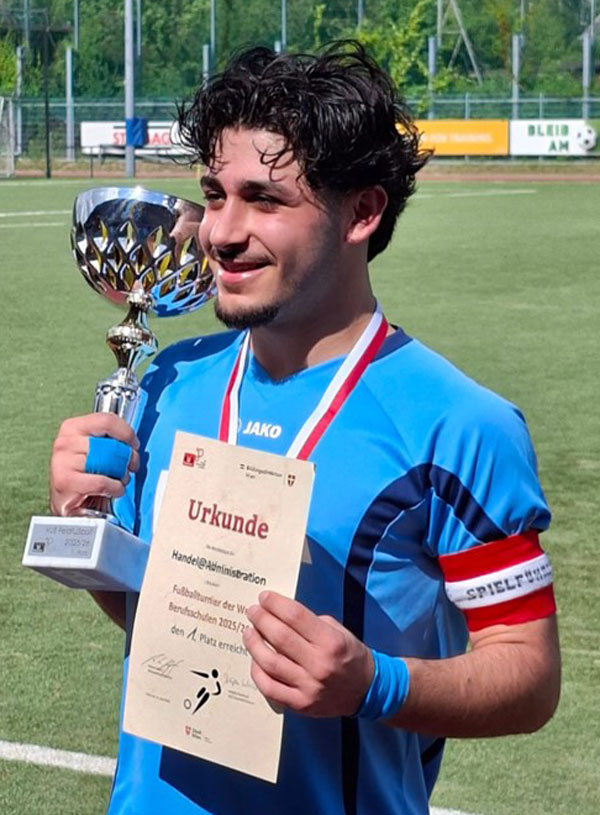 Der Kapitän der Mannschaft mit dem Pokal und der Urkunde.